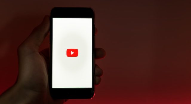 Persona que sostiene un teléfono inteligente con la aplicación de YouTube abierta